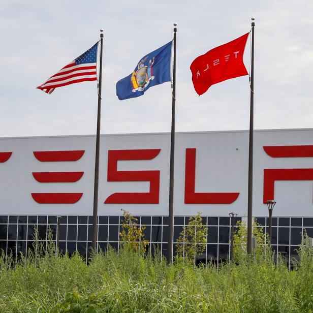 Flags fly over the Tesla Inc. Gigafactory 2, which is also known as RiverBend, a joint venture with Panasonic to produce solar panels and roof tiles in Buffalo, New York