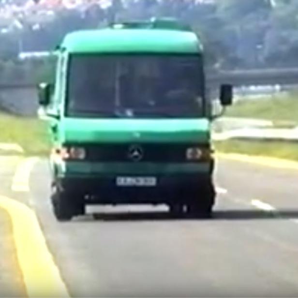 Ein grüner Mercedes-Benz Transporter fährt auf einer Landstraße.