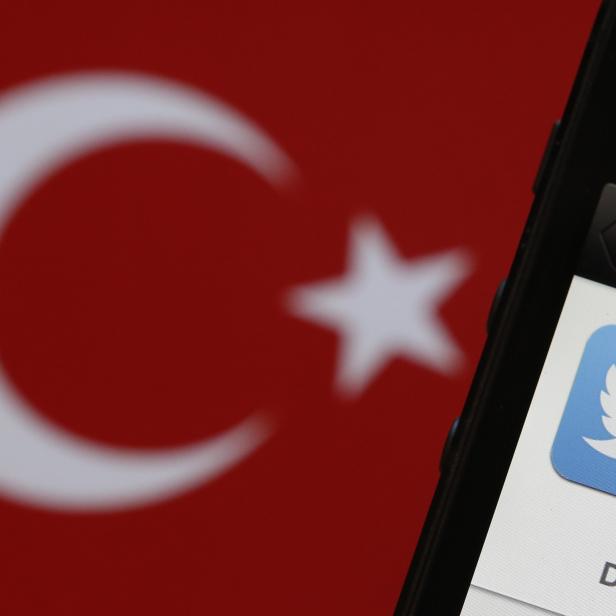 Photo illustration of Twitter logo on an iPhone display next to a Turkish flag