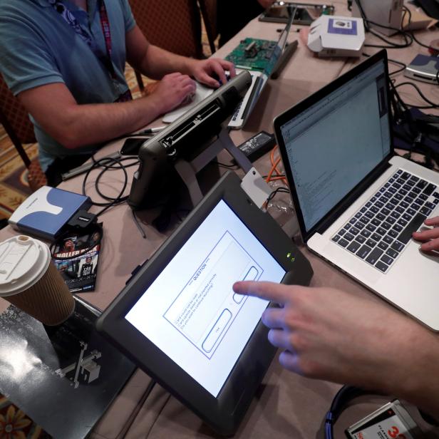 FILE PHOTO: Hackers try to access and alter data from an electronic poll books in a Voting Machine Hacking Village during the Def Con hacker convention in Las Vegas