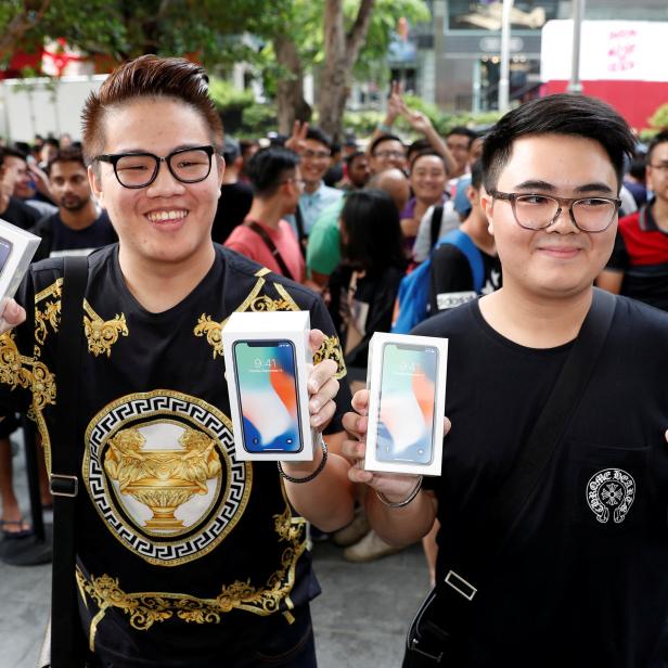 FILE PHOTO: First customers to buy iPhone X Kittiwat Wang, 22, and Mod, 22, of Bangkok pose with their iPhone X at the Apple store in Singapore