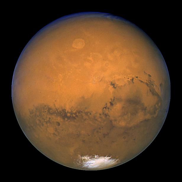 Der Planet Mars mit seiner rötlichen Oberfläche und den polaren Eiskappen.
