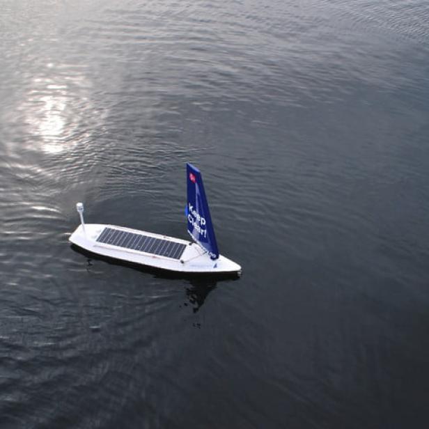 Ein kleines, solarbetriebenes Boot fährt auf dem Wasser.
