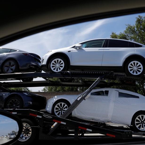 Newly manufactured Tesla vehicles are  transported along a freeway in Los Angeles, California