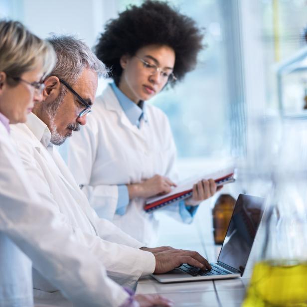 Group of doctors analyzing medical data on laptop in the laboratory.