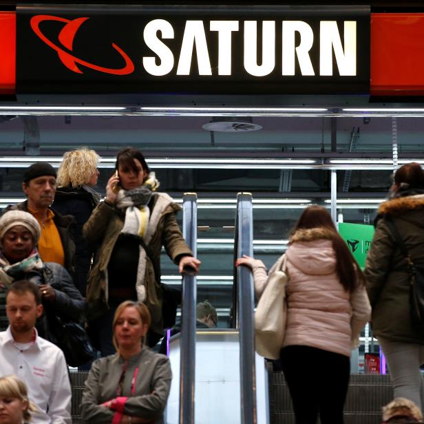 FILE PHOTO: People use escalators at a Saturn electronic retailer inside a shopping mall in Magdeburg