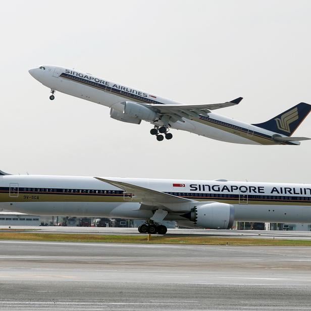 FILE PHOTO: A Singapore Airlines Airbus A330 plane takes off behind a Boeing 787 Dreamliner at Changi Airport in Singapore