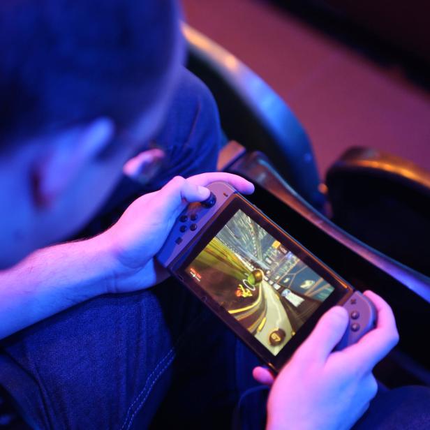 A fan plays Rocket League on a Nintendo Switch during day one of the Rocket League Championship Series Finals in London