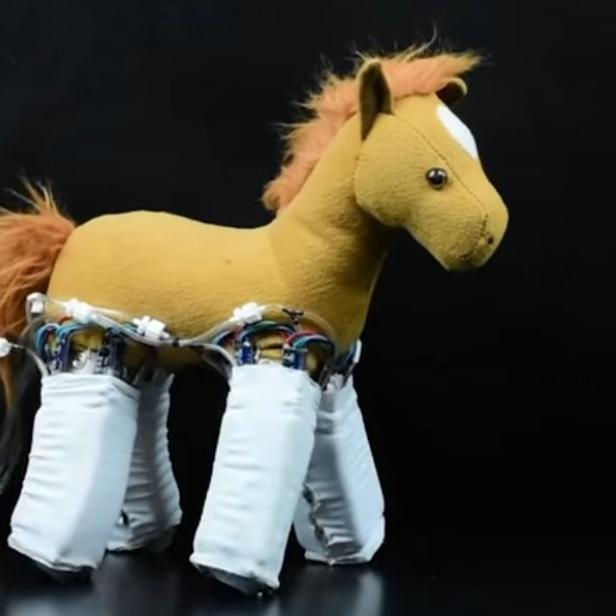 Ein Stoffpferd mit einer sichtbaren Roboterstruktur anstelle der Beine.