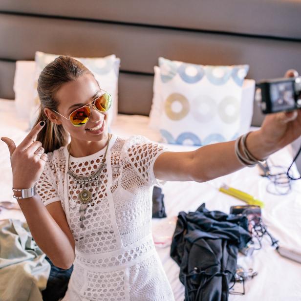 Young woman taking a selfie wearing colorful goggles.