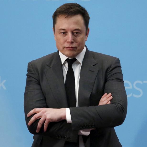 FILE PHOTO: Tesla Chief Executive Elon Musk stands on the podium as he attends a forum on startups in Hong Kong