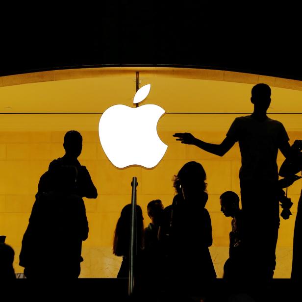 FILE PHOTO: Customers walk past an Apple logo inside of an Apple store at Grand Central Station in New York