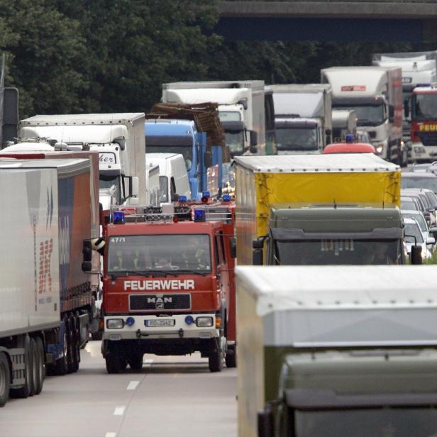 Ein Stau auf der Autobahn mit vielen Lastwagen und einem Feuerwehrwagen.