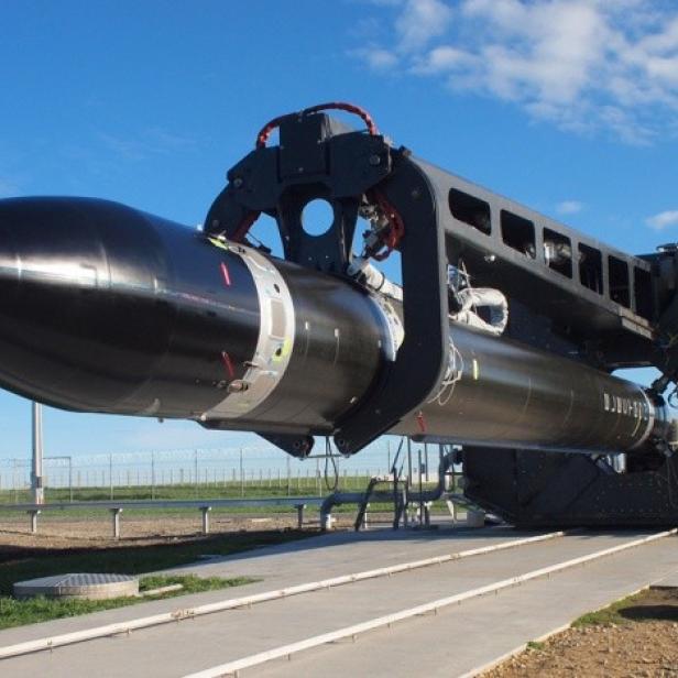 Eine schwarze Rakete wird von einer Trägerkonstruktion gehalten.