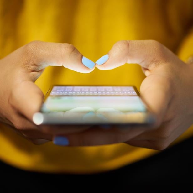 Woman Typing Phone Message On Social Network At Night