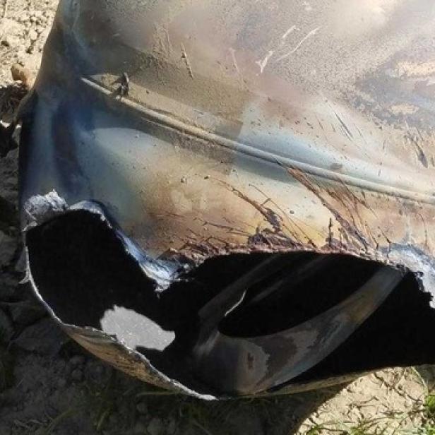 Ein zerstörter, metallischer Gegenstand liegt auf dem Boden.