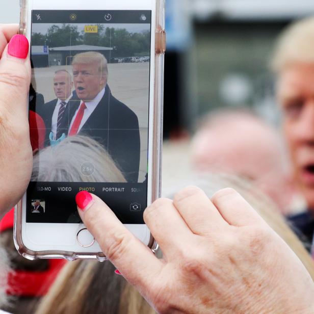 Woman shoots a mobile phone picture of U.S. President Trump as he arrives for an evening campaign rally in Cincinnati, Ohio