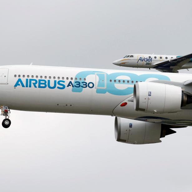 An Airbus A330neo aircraft lands as a Dassault Aviation Falcon jet of AVdef (Aviation Defense Service) flies nearby during its maiden flight event in Colomiers near Toulouse