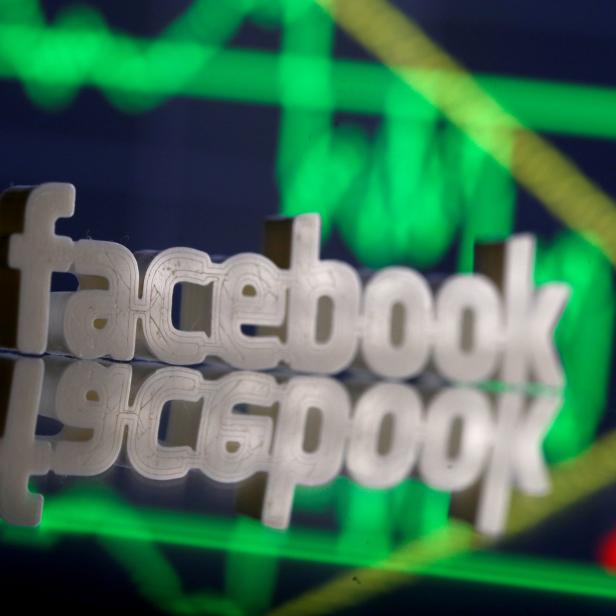 FILE PHOTO: A 3D-printed Facebook logo is seen in front of displayed stock graph