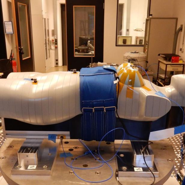 Ein Crashtest-Dummy liegt auf einem Tisch in einem Labor.