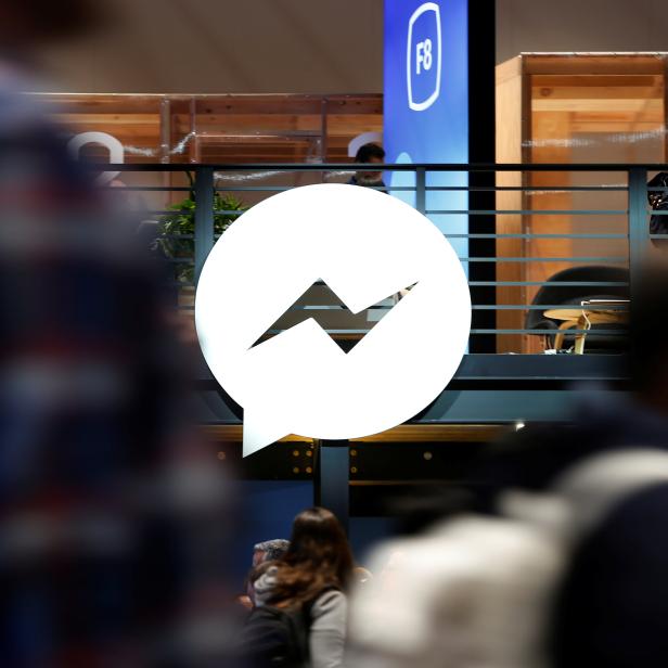 Attendees walk past a Facebook Messenger logo during Facebook Inc's annual F8 developers conference in San Jose, California