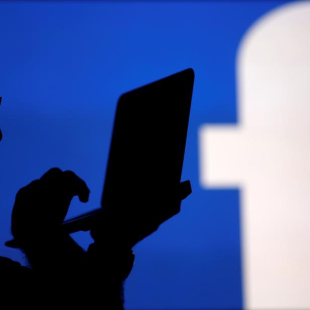 FILE PHOTO: A man is silhouetted against a video screen with an Facebook logo in this photo illustration in Zenica