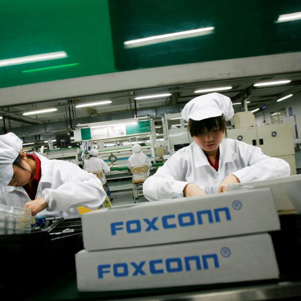 FILE PHOTO: Employees work inside a Foxconn factory in the township of Longhua in the southern Guangdong province