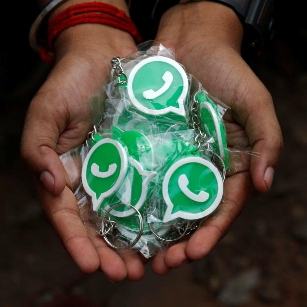 A WhatsApp-Reliance Jio representative displays key chains with the logo of WhatsApp for distribution during a drive by the two companies to educate users, on the outskirts of Kolkata