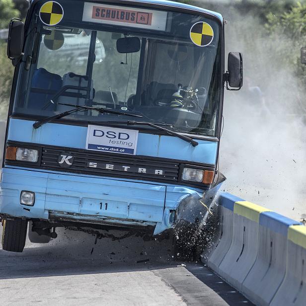 Ein Schulbus kollidiert während eines Crashtests mit einer Betonbarriere.