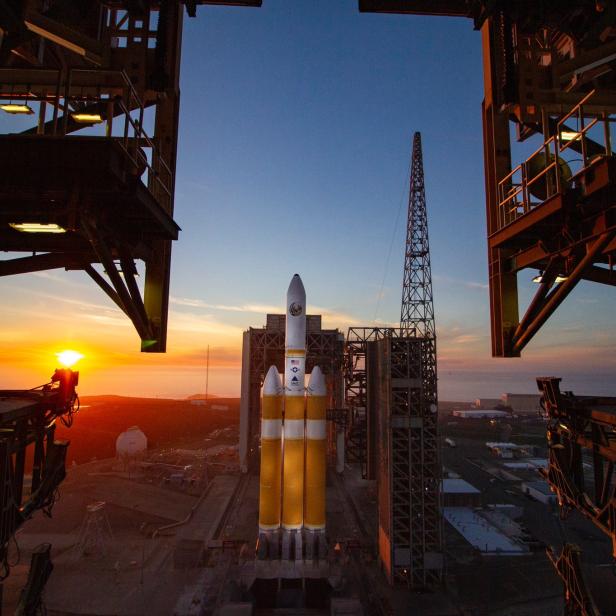 Eine Trägerrakete steht bei Sonnenaufgang auf einer Startrampe.