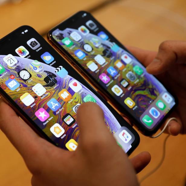 FILE PHOTO: A customer compares the size of the new iPhone XS and iPhone XS Max at the Apple Store in Singapore