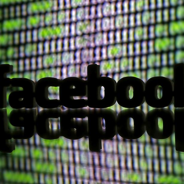 FILE PHOTO: A 3D printed Facebook logo is seen in front of displayed cyber code