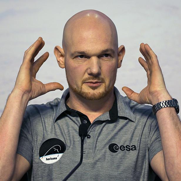 Ein Mann im ESA-T-Shirt gestikuliert mit beiden Händen zum Kopf.