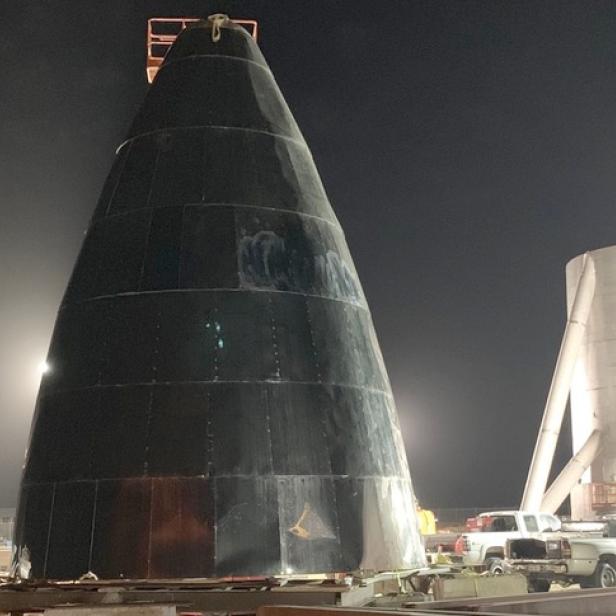 Ein Starship-Prototyp steht nachts auf einer Startrampe.