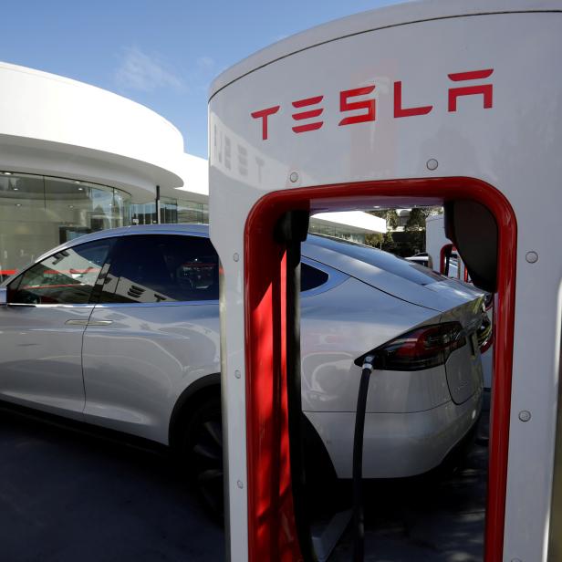 FILE PHOTO: A Tesla Model X vehicle is charged by a supercharger outside a Tesla electric car dealership in Sydney