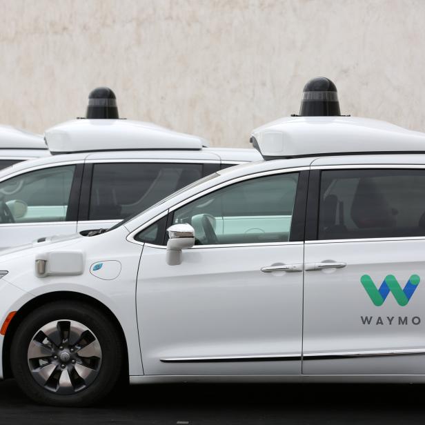 Three of the fleet of 600 Waymo Chrysler Pacifica Hybrid self-driving vehicles are parked and diaplayed during a demonstration in Chandler, Arizona