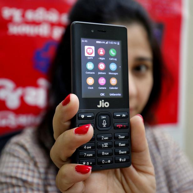 FILE PHOTO: A sales person displays JioPhone as she poses for a photograph at a store of Reliance Industries' Jio telecoms unit, on the outskirts of Ahmedabad