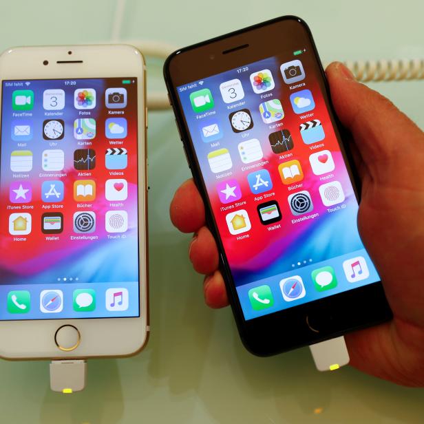 An employee of German Apple retailer Gravis displays an iPhone 7 and 8 in a store in Berlin