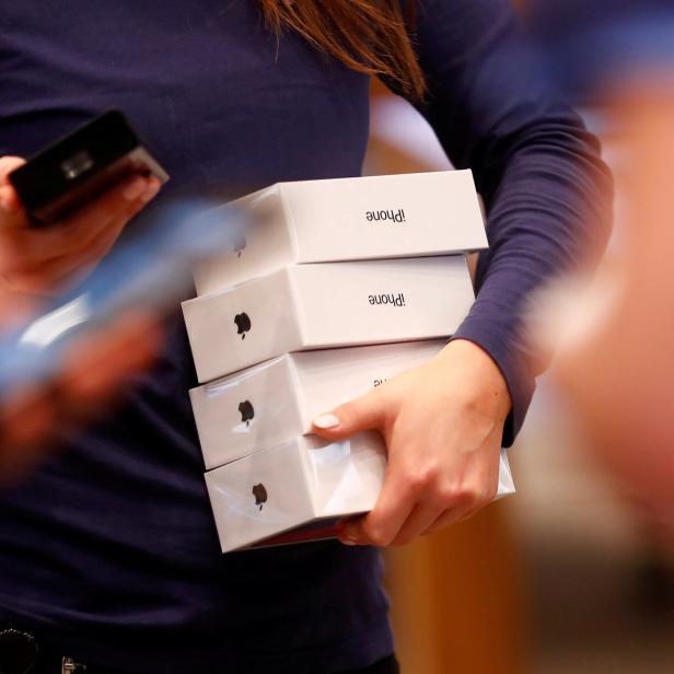 FILE PHOTO: Apple staff hold iPhone X packages at the Apple Store in Berlin