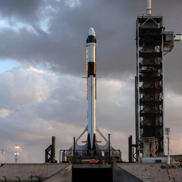 Eine SpaceX Falcon 9 Rakete steht auf einer Startrampe unter einem bewölkten Himmel.