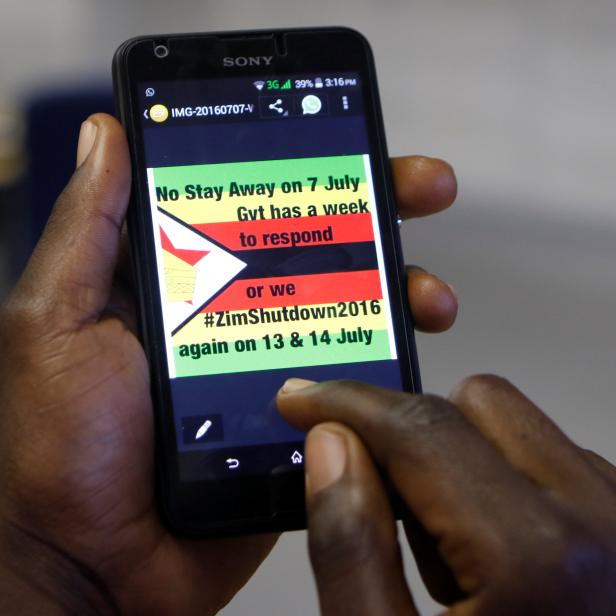 A man checks a message on his mobile phone, in Harare