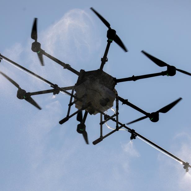 Drone flies and sprays chemicals during an operation to reduce air pollution in Bangkok