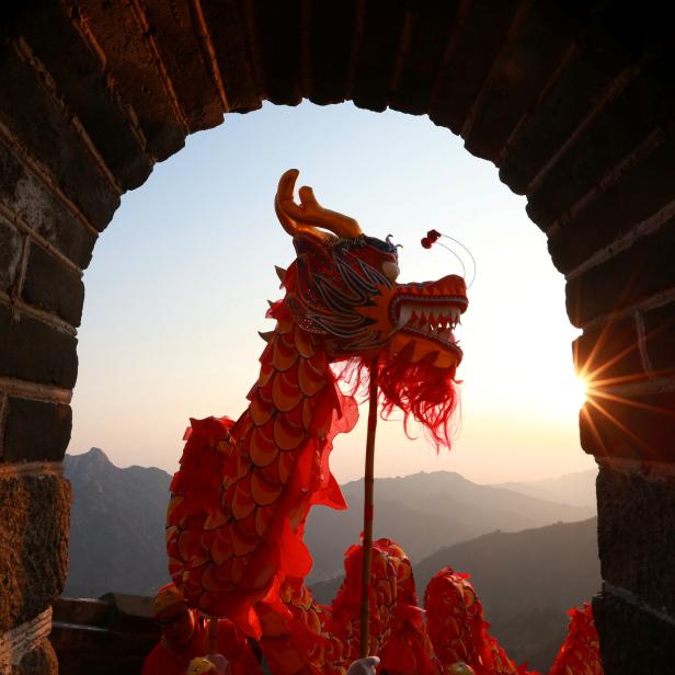 Performers take part in a dragon dance during sunrise at the Mutianyu section of the Great Wall of China in Huairou district of Beijing