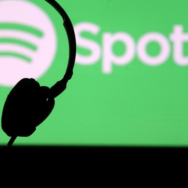 FILE PHOTO: A headset is seen in front of a screen projection of Spotify logo, in this picture illustration