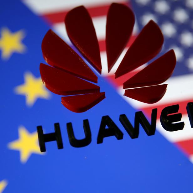 FILE PHOTO: A 3D printed Huawei logo is placed on glass above displayed EU and US flags in this illustration