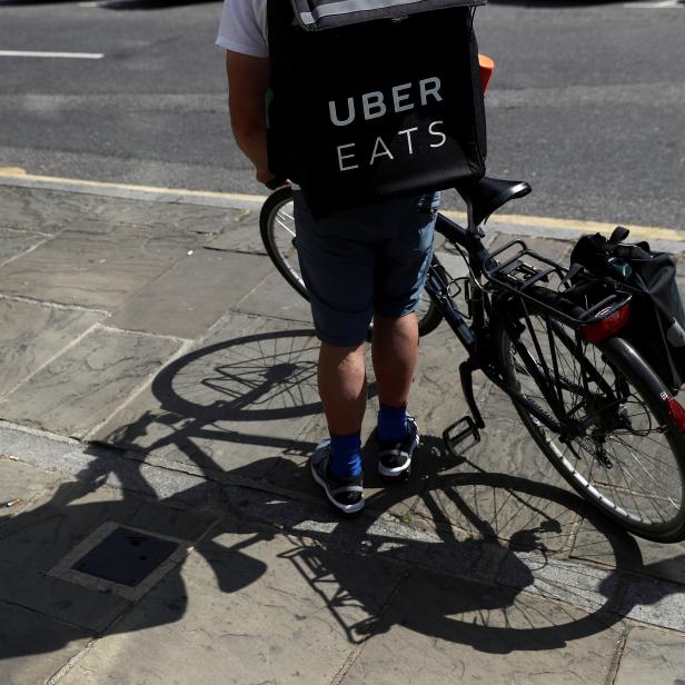 FILE PHOTO: A cyclist prepares to delivery an Uber Eats food order in London