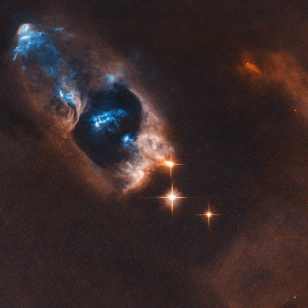 Die Geisterkopf-Nebel leuchtet blau und orange im Weltraum.