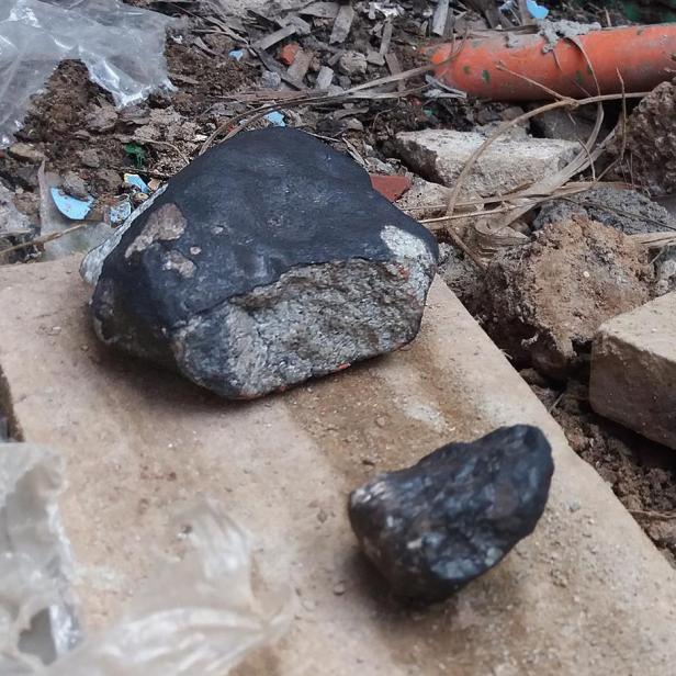 Zwei Meteoriten liegen auf einem Ziegelstein in Kuba.