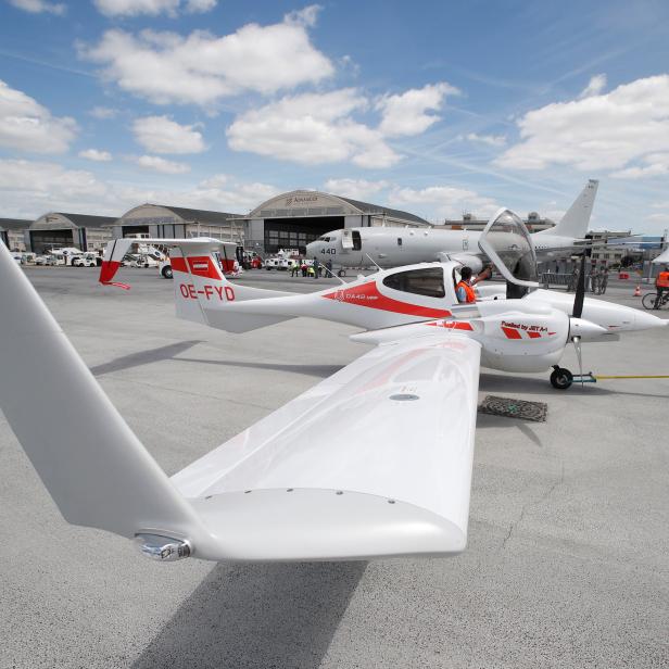 Workers move a Diamond DA42 MPP aircraft on the static display, before the opening of the 52nd Paris Air Show at Le Bourget airport near Paris