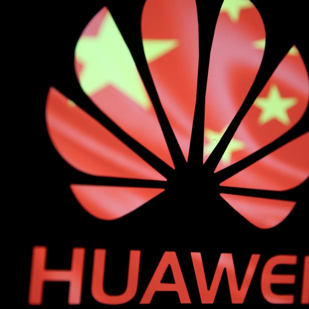 A 3-D printed Huawei logo is seen in front of displayed flag of China in this illustration